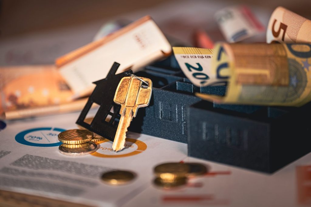 pexels-photo-29799518 Close-up of house keys, euro bills, and charts symbolizing real estate investment and finance.