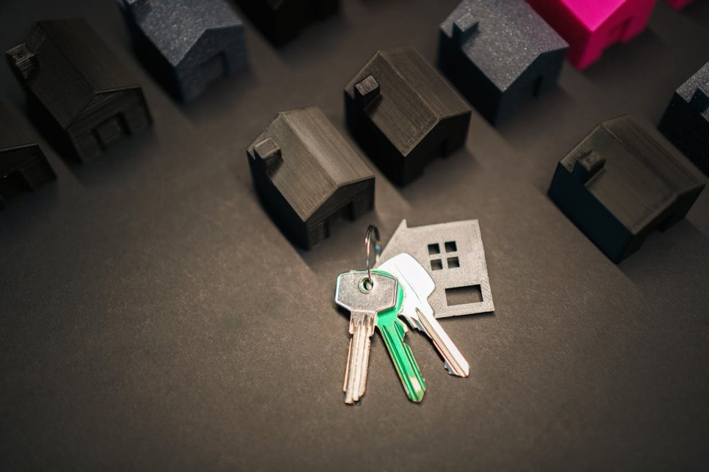 pexels-photo-31424880 Miniature house models and keys symbolize real estate investment and housing market.